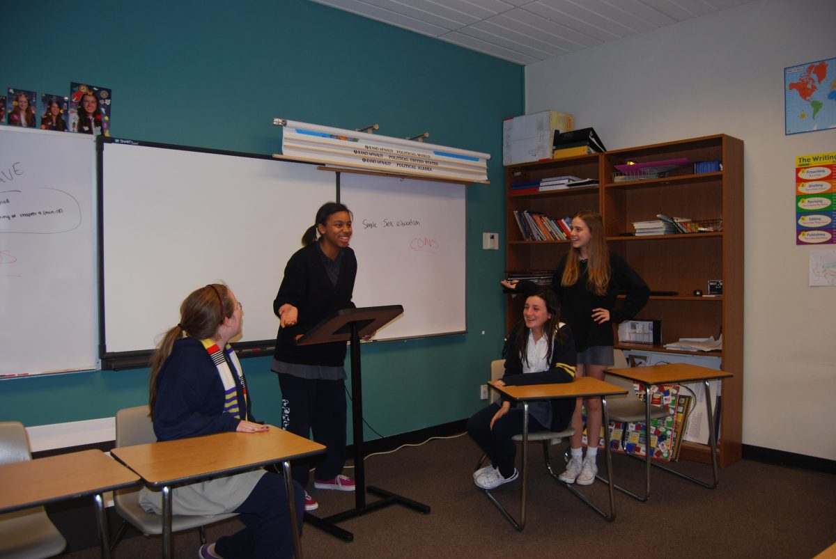 DEBATERS: Middle school debaters Alexandra 15, Ellie 16, Emma 15, and Lilia 15, from left to right, demonstrate a mock argument about same sex education. Photo by Celine 11