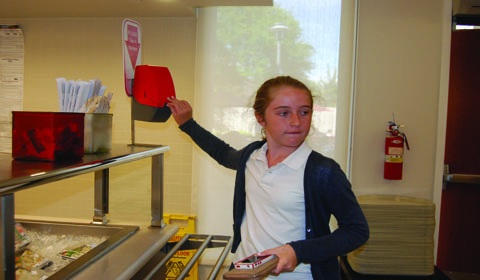 Maya Feltheimer 18 uses the new number system in Café M to order food from the grill. Photo by Margaret 15.