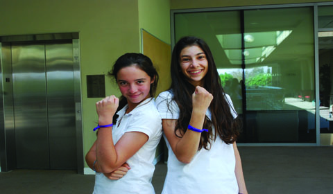 Sammi 15 and Laura 15 show off their purple honor bracelets, handed out by All School Council during the Honor Assembly. Photo by Ariella 15