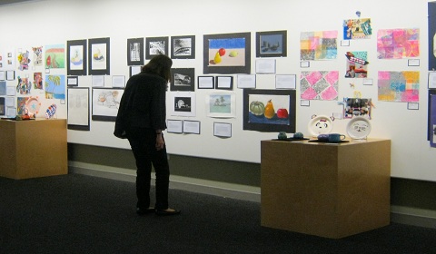 A parent admires the drawings on display in Seaver Gallery for the Winter Art Show. 
