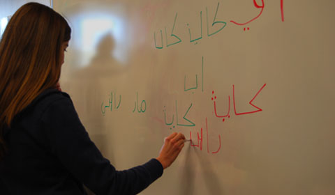 A club member writes in Arabic on the white board. Photo by Lilia '15