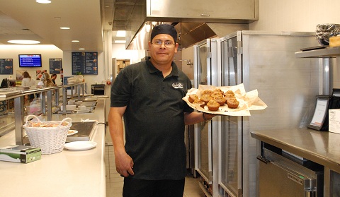 José Luis Morales holds a plate of muffins from Cafe M’s breakfast selection. Photo by Kayleigh '18 / Staff Photographer