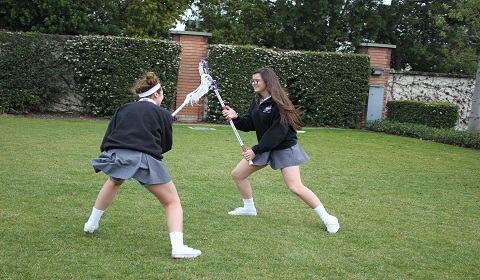 Sophie 14 and Kathryn 14 show off their lacrosse skills on the field during Fitness Week. Photo by Suhuana