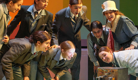 Members of the cast gather around a television prop. Photos by Rand Bleimeister, Contributing Photographer.