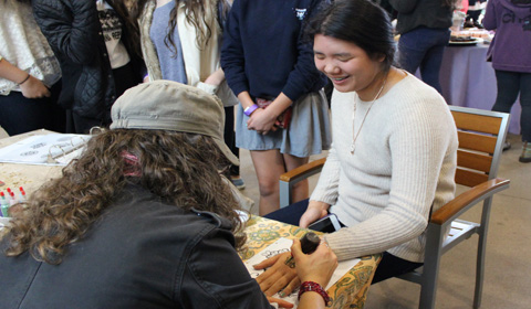 Gillian 17 gets a henna tattoo on her hand at Winter Fest. 