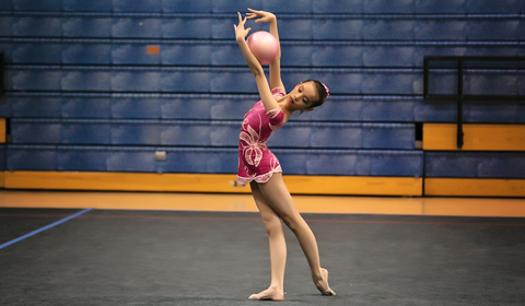 Isabella 18 performs with ball apparatus at her competition. 