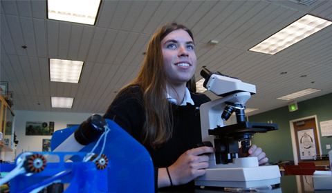 Nicki '16  studies bioluminescent noctiluca through a microscope. Photo by Chris Colthart.