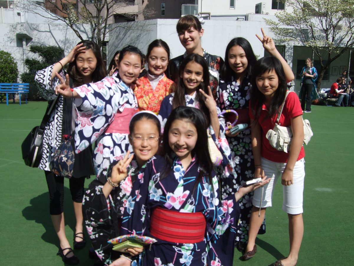 Ms. Fish poses with students from her school in Tokyo 
