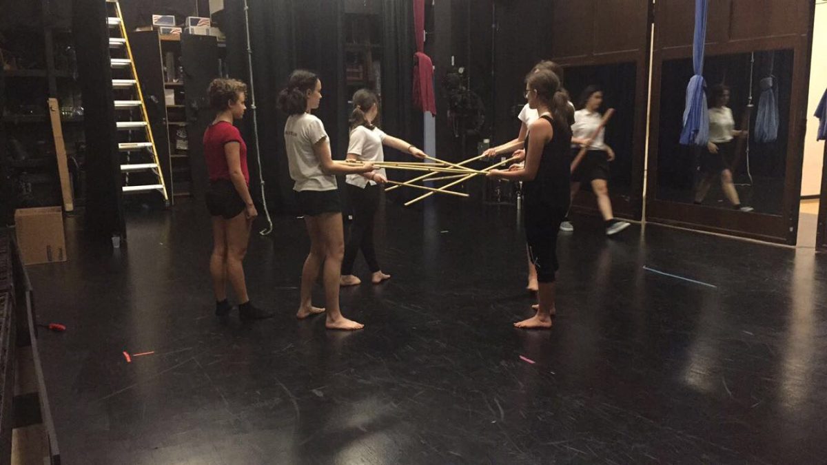 Students rehearse with props for their upcoming performance.