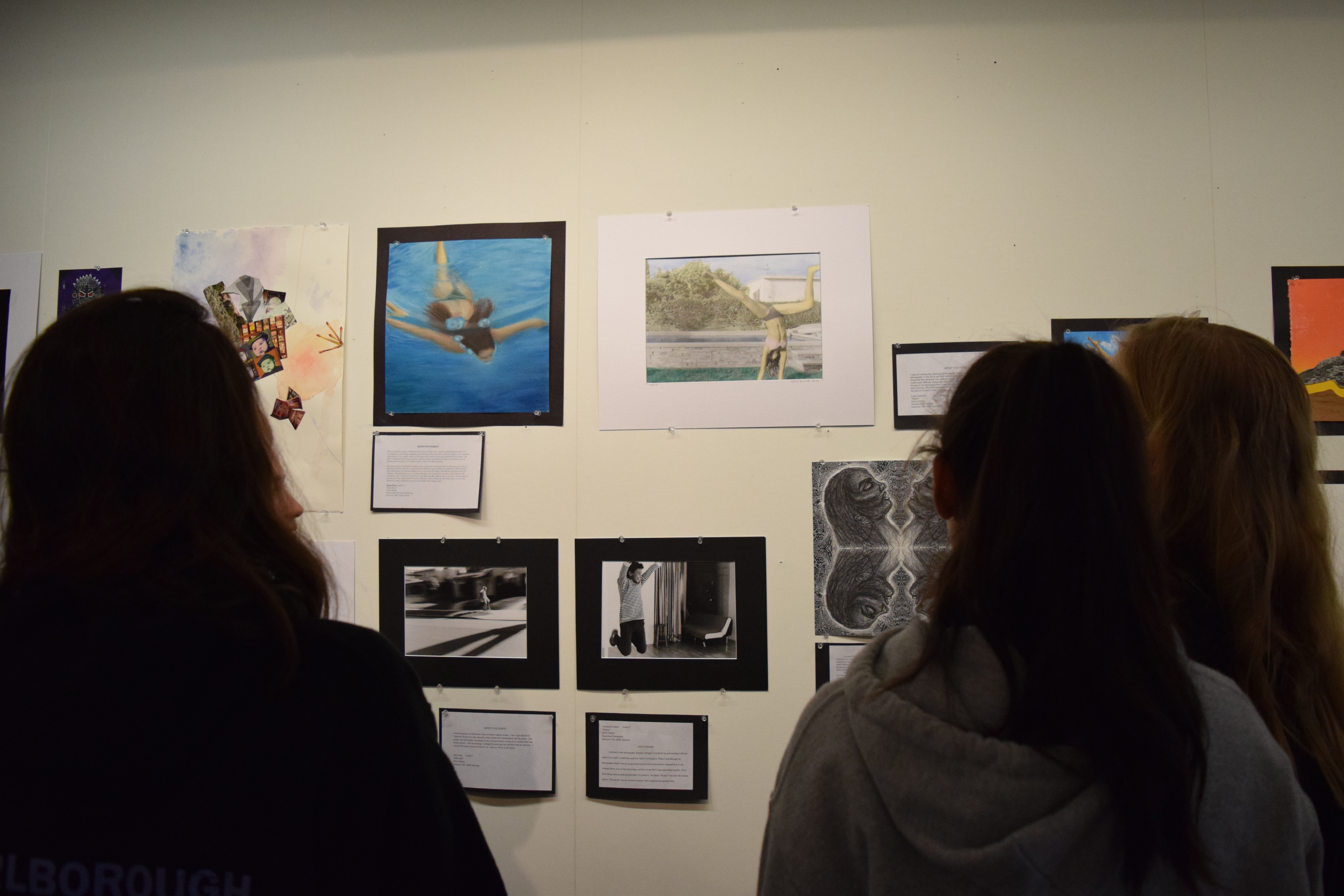 Students ponder photographs in the gallery.