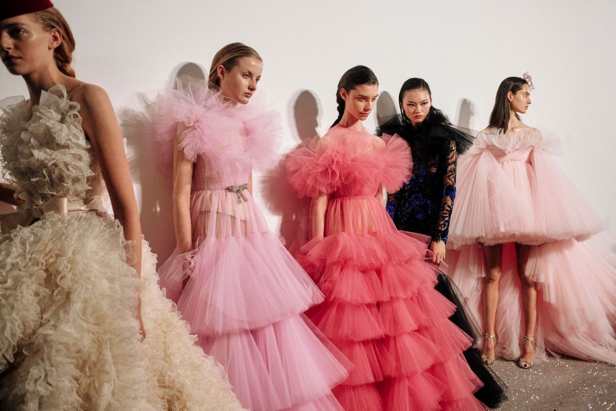 Models in Giambattista Valli wear sheer layered tulle dresses backstage at Couture Fashion Week Spring Summer 19. Courtesy of Jamie Stoker. 