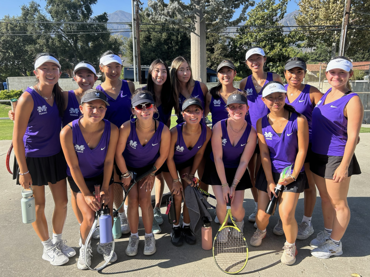 The varsity tennis team smiles for a photo before a tennis match.