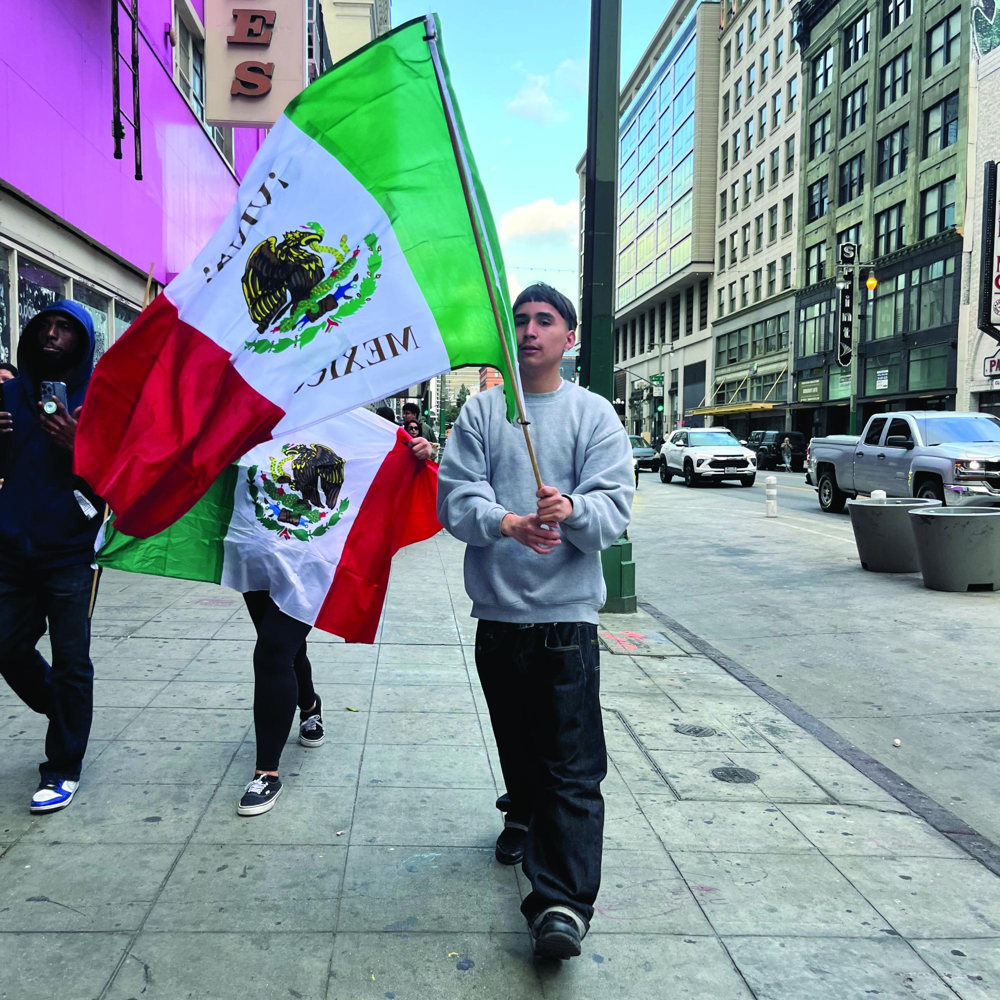 Protester waves Mexican flag in downtown Los Angeles on Feb. 4.